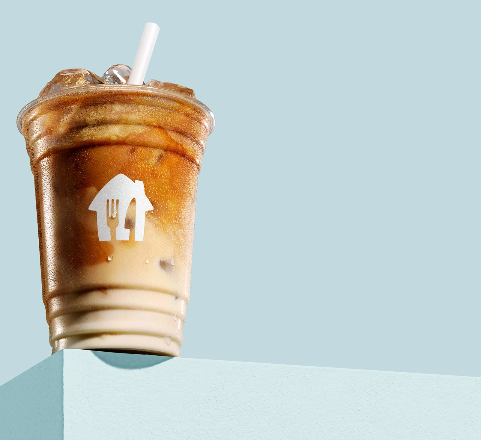 kawa latte z lodem, w plastikowym kubku z nadrukowanym logo Pyszne.pl